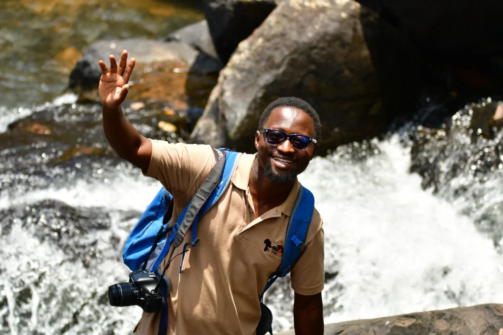 Expert guide Michael Msuya climbing rocks while on safari in Tanzania.